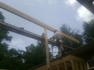 Carpenter setting a ridge beam over a new addition frame — Ice Dam Removal by Roofing Brothers in Germanton