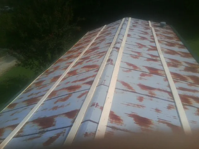 Rusted metal roof panels with new wood purlins before replacement — Storm Damage Roof Repair in Germanton by Roofing Brothers