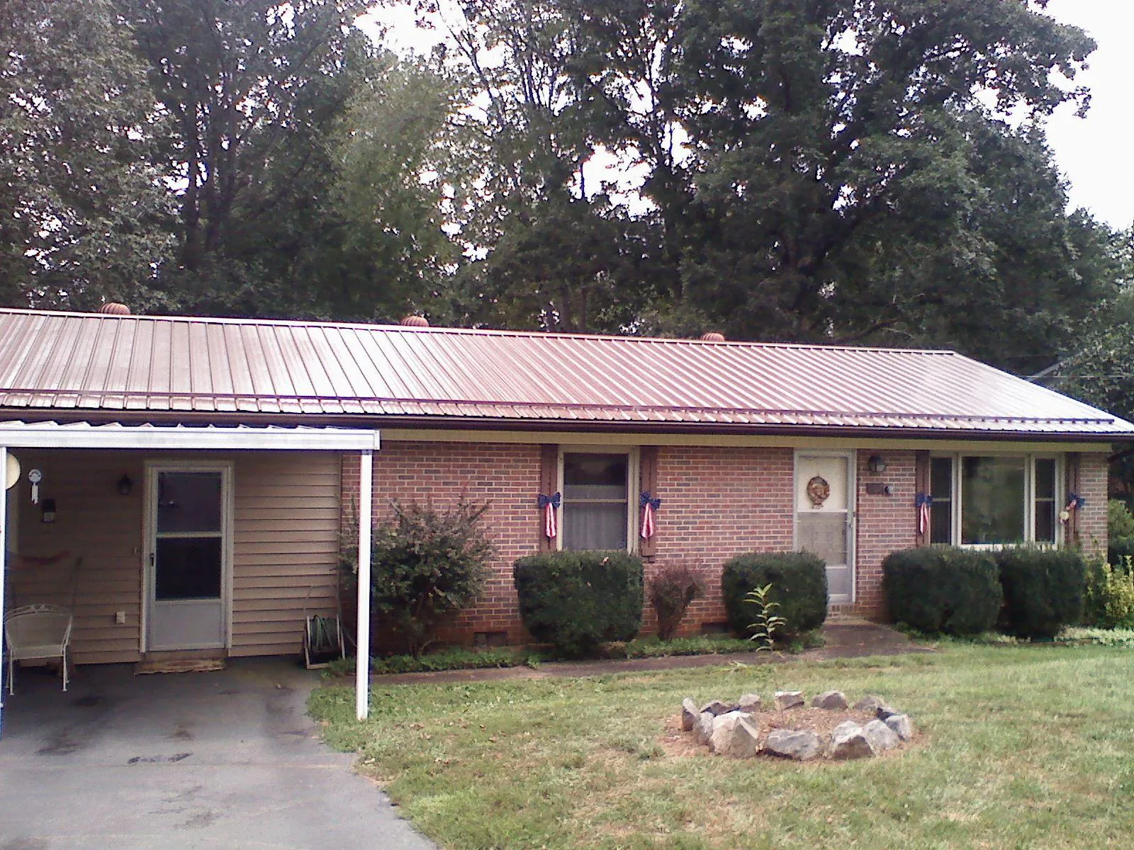 Bronze metal roof and carport on a brick ranch home — Roof Repair work by our crew in Germanton